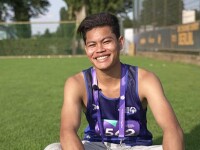 Young man sitting in a field on the grass. 
