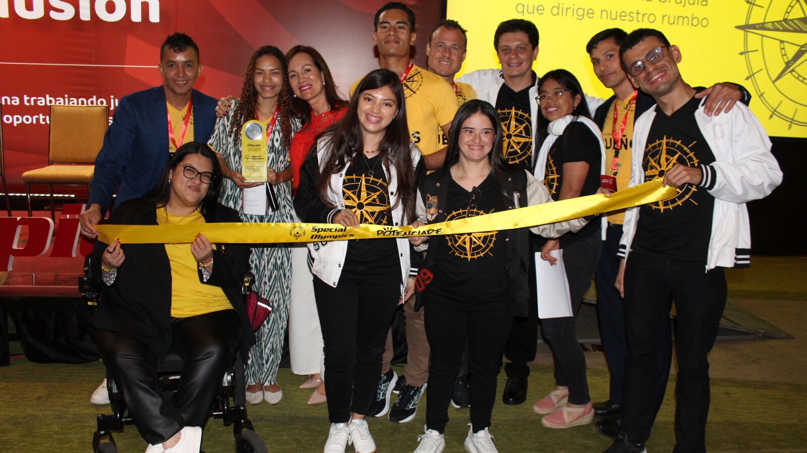 Hombres y mujeres miembros de Olimpiadas Especiales posan para foto