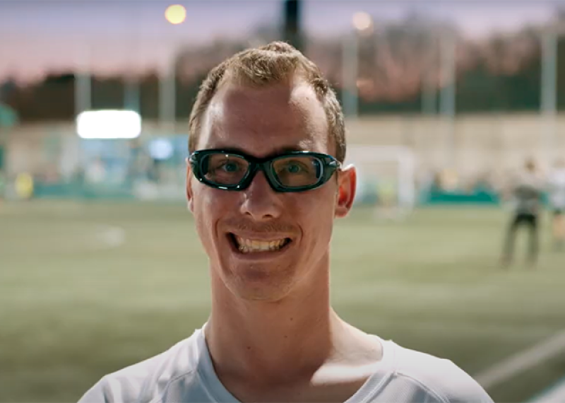 Man in athletic glasses smiling. 