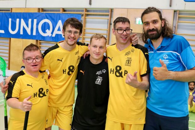 A group of five people facing camera with their thumbs up