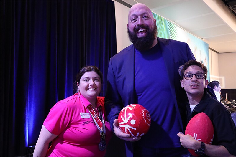 Global Ambassador Big Show standing between athletes Michelle Canazaro and Sebastian Cespedes.