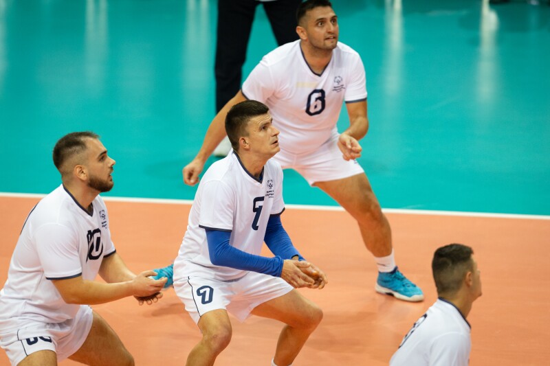 Saša Mutapović gets ready to serve the ball surrounded by his teammates
