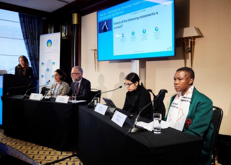 Special Olympics Zimbabwe Health Messenger Barbara Njovo sits among other speakers at a table.