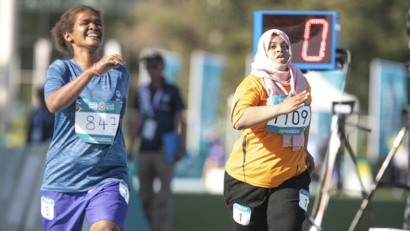 Two female athletes compete in an athletics race.