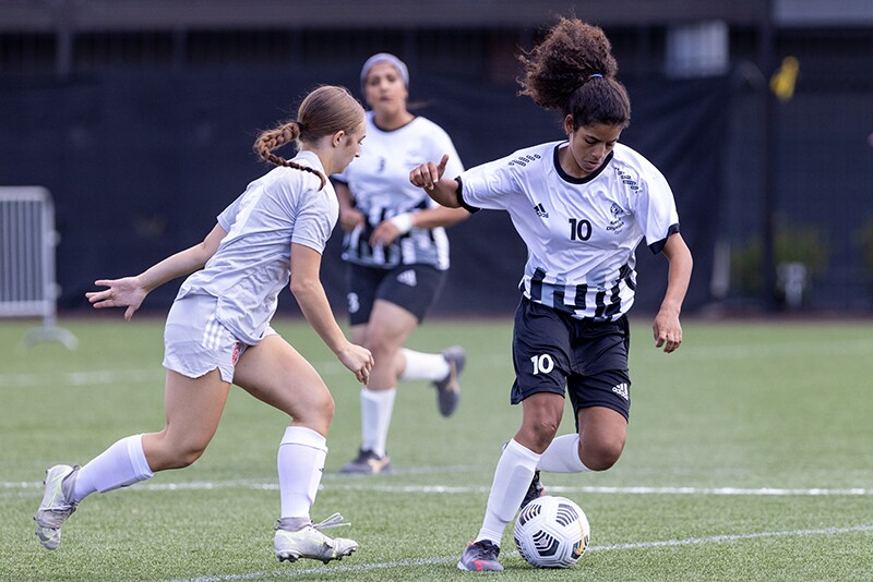 Female footballer on the pitch making a play. 