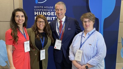 Four people standing together for a photo. 