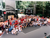 A large group of athletes gather together on a basketball court. 