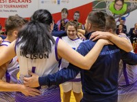 A team of 7 people wearing blue jerseys hugging and jumping