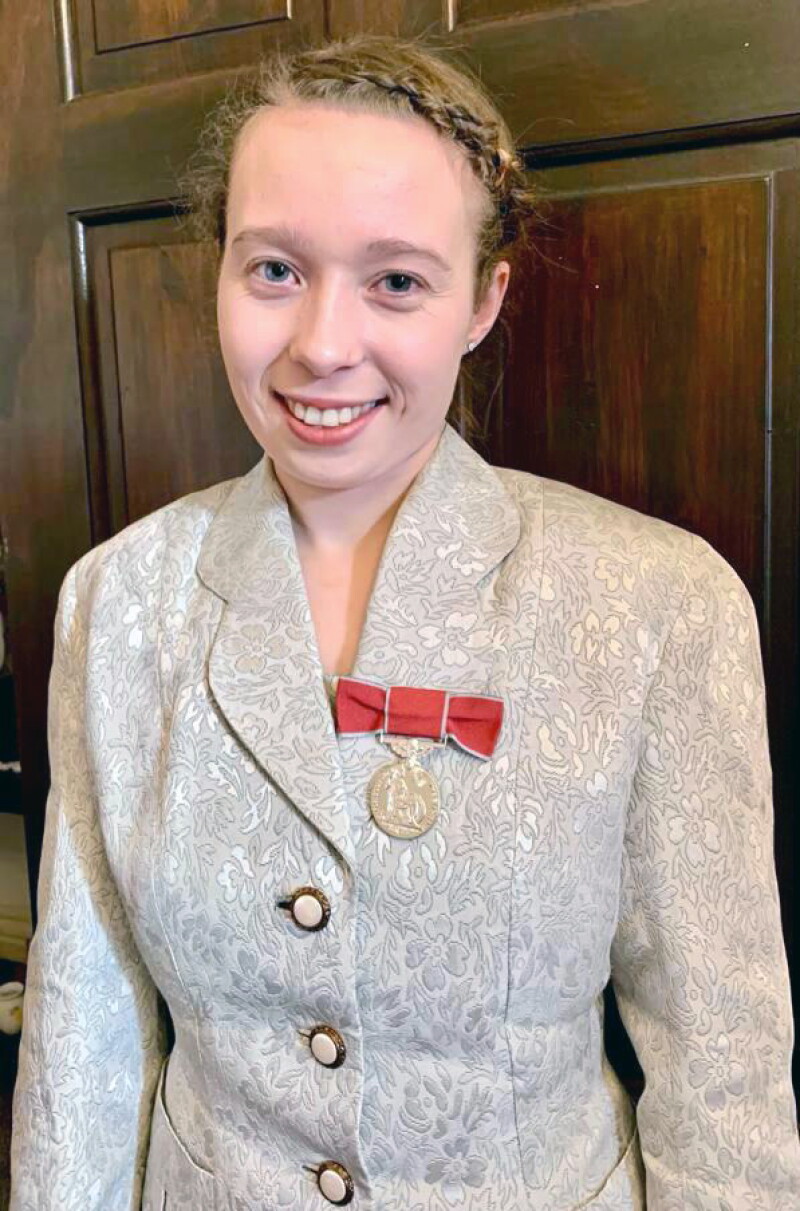Kiera, wearing the British Empire Medal and smiling.  