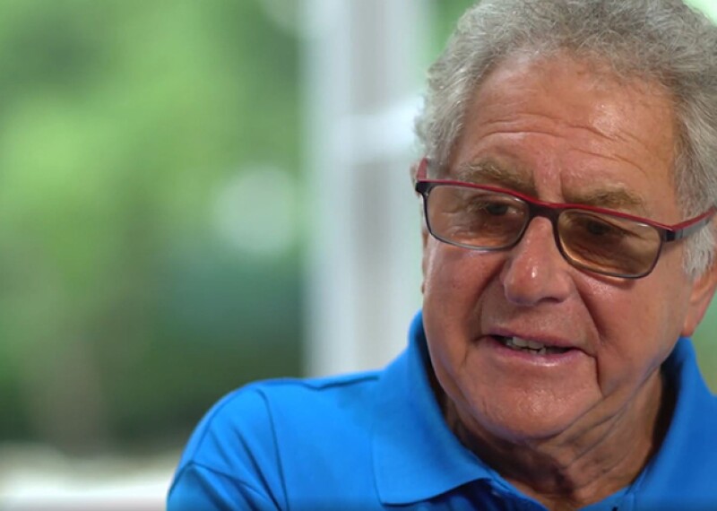 Doctor Richard Perlman sitting for an interview. He has on an blue polo shirt. 