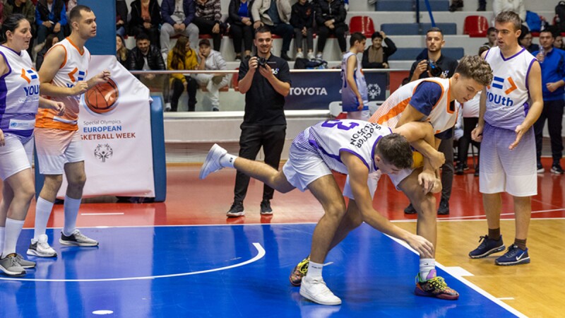 Ongoing basketball match with two players trying to catch the ball